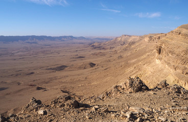 The desert landscape with the big valley, the sandstone mountains on its edge, the blue sky