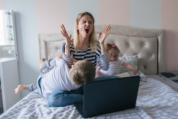 Mother working from home with kids. Quarantine and closed school during coronavirus outbreak....