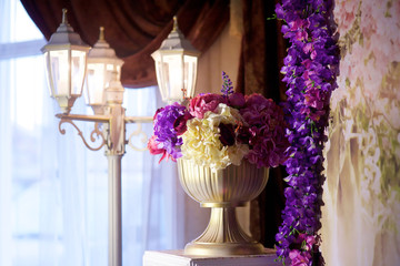 A vase with flowers and a lantern as a decor and decoration