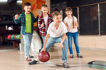 Little children playing bowling in club - obrazy, fototapety, plakaty