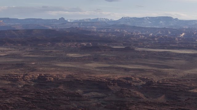 A long-lens timelapse looking across Canyonlands National Park and the distant Abajo Mountains as seen from Needles Overlook.