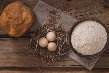 Village freshly baked bread on a table with eggs and flour