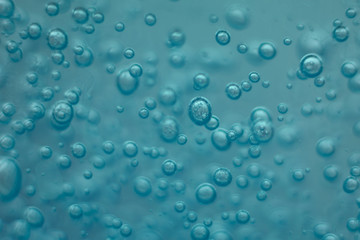 Many round bubbles of the shower gel on the blue background.