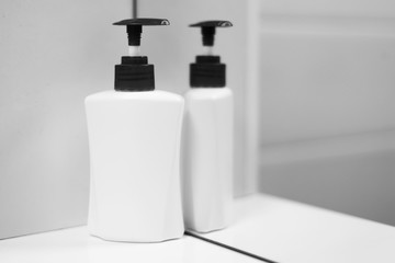 A bottle of soap with reflection in mirror.