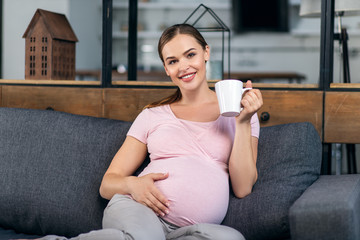 Pregnant woman with a cup in his hands