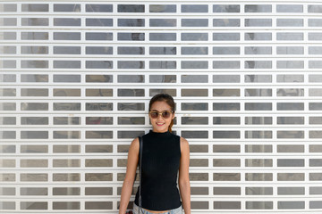 Happy young Asian tourist woman with sunglasses smiling