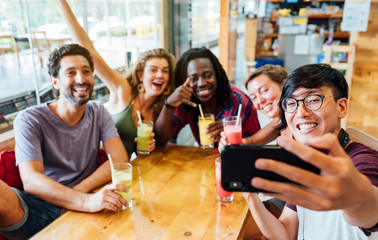 A group of multiethnic friends having a selfie at a restaurant. Concept of friendship