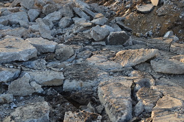 Broken pieces of asphalt at a construction site. Recycling and reuse crushed concrete rubble, asphalt, building material, blocks. Crushed сoncrete Background. Road repair, replacement of old pavement