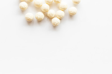 Fototapeta na wymiar Coconut candy balls on white background top view copy space