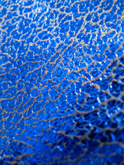 Metallic and electric blue fabric with shiny reflective cracked surface