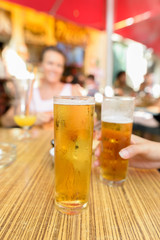 Happy Friends Drinking Beer Outdoors With Woman Smiling on Background