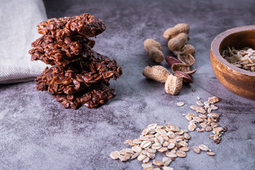 Oatmeal cookies pile with peanuts and flakes on concrete background. Healthy snack. Close up view.