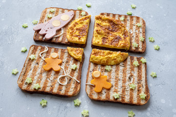 Funny cosmos sandwiches with rocket and astronauts on the omelet moon