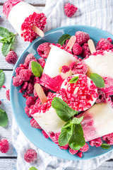 Sweet and tasty diet summer dessert. Homemade raspberry yogurt popsicle with fresh raspberries and mint. Healthy ice cream recipe. Wooden white background copy space