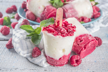 Sweet and tasty diet summer dessert. Homemade raspberry yogurt popsicle with fresh raspberries and mint. Healthy ice cream recipe. Wooden white background copy space