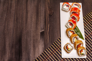 Assorted sushi set. Japanese or Korean roll with different fresh ingredients. Trendy black background
