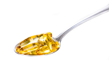 Spoonful of fish oil gel capsule containing omega-3 polyunsaturated acid EPA and DHA enhances heart and health.