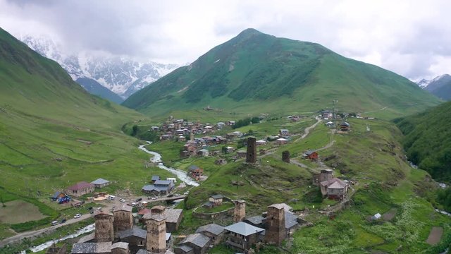 Ancient stone towers and Ushguli village at the foot of Mt. Shkhara. Picturesque and gorgeous scene. Rock tower towers and old houses in Ushguli.