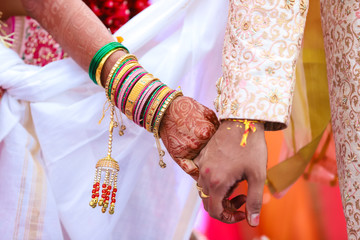 Traditional indian wedding ceremony, groom holding bride hand