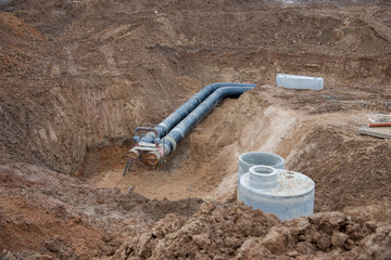 Laying drain pipes and concrete manholes for stormwater system. Connecting a trench drain to a...