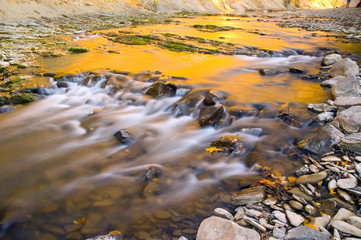 Mountain stream illuminated by the setting sun
