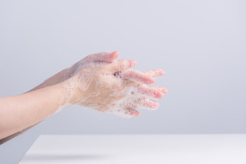 Obraz na płótnie Canvas Washing hands. Asian young woman using liquid soap to wash hands, concept of hygiene to protective pandemic coronavirus isolated on gray white background, close up.