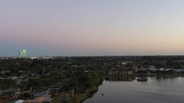Aerial pan left of evening near Hollywood Florida over a lake and residential area, Hard Rock Resort