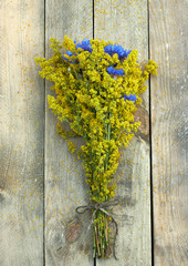 Wild field summer flowers bouquet flat on the wooden background, overhead top view from above, rustic floral design concept, copy space
