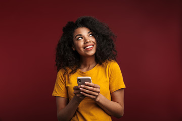 Image of african american woman looking upward and using cellphone