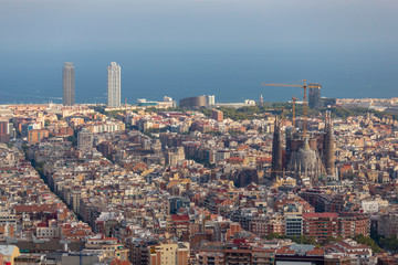 Barcelona city view from a high point with Sagrada Familia Cathedral in the middle and the sea at the background