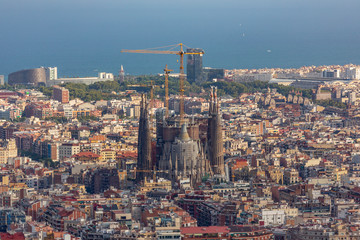 Barcelona city view from a high point with Sagrada Familia Cathedral in the middle and the sea at the background