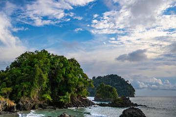 beautiful view of a rocky caribbean coast with dense tropical vegetation at sunset