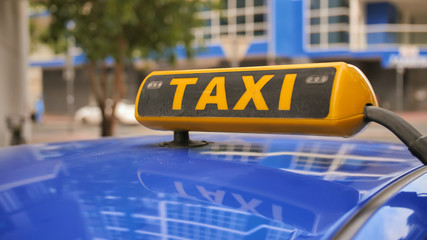 Yellow taxi sign on a car roof. Dubai Taxi.
