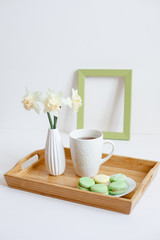 Wooden breakfast tray with a bouquet of spring flowers in bed. .a Cup of morning tea with macaroons and a flower