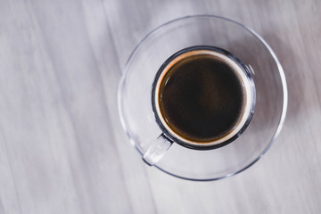 Closeup glass of hot americano coffee on wood table, selective focus, vintage tone