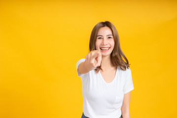 Portrait young happy asian woman smile laughing standing enjoy fun relaxing carefree positive emotion in white t-shirt, Yellow background isolated studio shot and copy space.