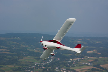 Ekolot KR-030 Topaz aircraft in flight over the forest