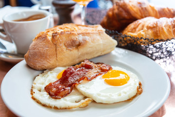 Breakfast with coffee and croissants in a basket on table