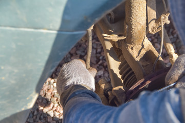 man repairs a car wheel on a Sunny day on the road