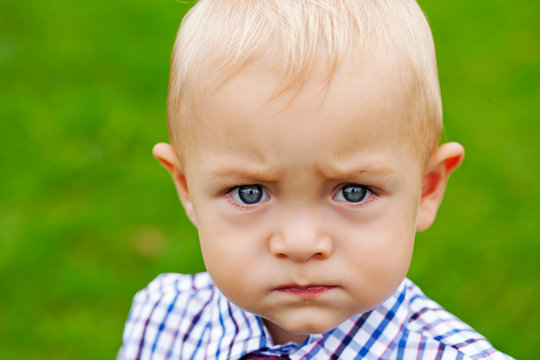 Portrait of throwing or displeased little boy looking at camera