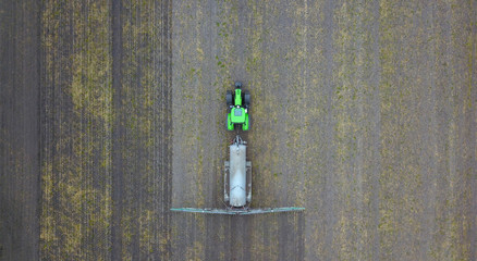 agriculture: tractor with slurry tanker on a field, aerial view