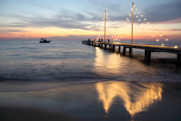 Fototapeta na wymiar romantic beautiful sunset on the beach with bridge and light at Koh kood Trat Thailand
