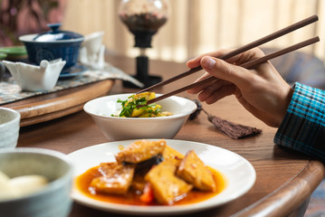 A man is eating in a chinese restaurant.