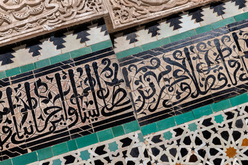 Wall detail with carved plaster and koranic verse calligraphy, Bou Inania Madrasa in Fes.