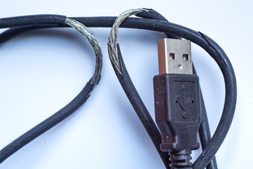 Damaged black usb cable plug and micro usb plug or Old Smart Phone Charger Cable broken on white acrylic background, Close up & Macro shot, Select focus, Technology, Business concept