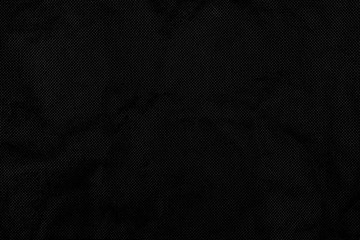 Black fabric texture. Dark abstract background. Uneven surface