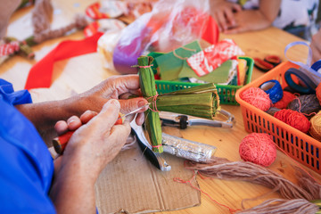 Creative items and crafts for children at home on the table. Paints and brushes, scissors, thread and scraps of fabric - the hands of the child and the parent in the background.