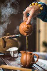 Tea ceremony. Tea is pouring from the kettle.