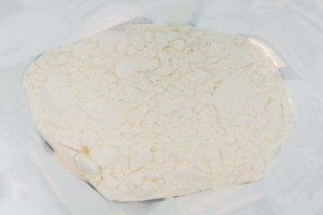 Powdered milk. White abstract texture. Light uneven rough background.