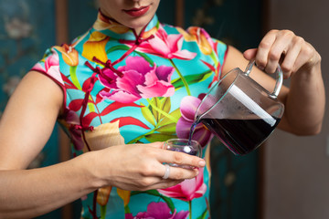  Chinese tea ceremony. Girl pours tea into a cup.